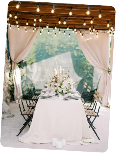 A decorated outdoor table under string lights.